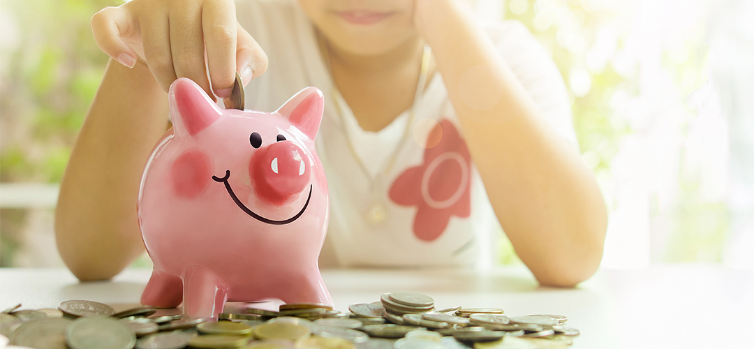 blog-featured_kid-savings kid putting coin in piggy bank