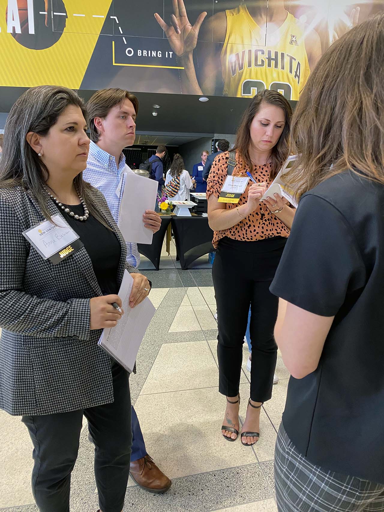 From left: Anna Baker, director - commercial services, Alex Durano, SBA lending associate, and Shumard listen to a participant speak about her team's venture.