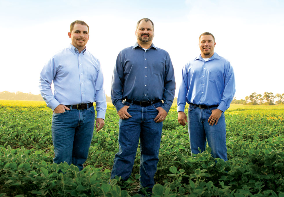 Three men standing in a field.