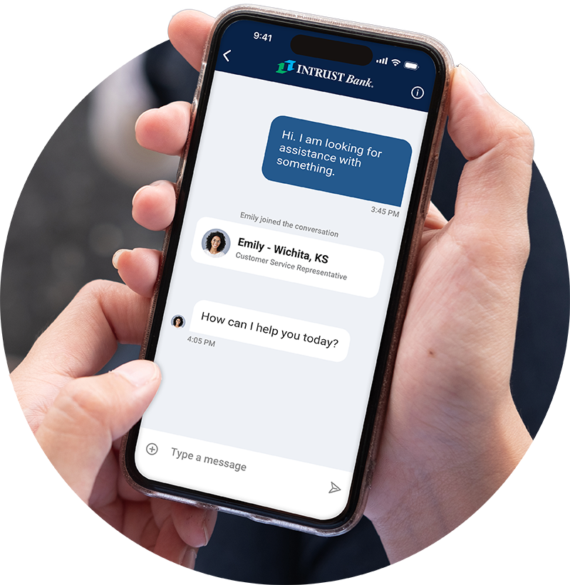 Hands holding a mobile phone showing the messaging feature of the INTRUST Bank app
