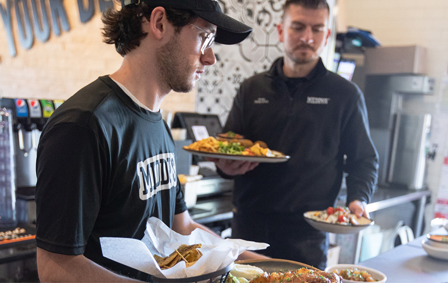 Meddys employees deliver food to a table