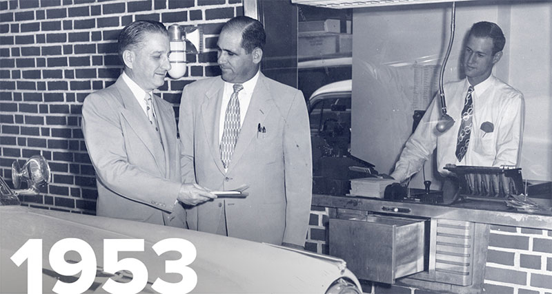 Old photo of two people talking in front of bank window